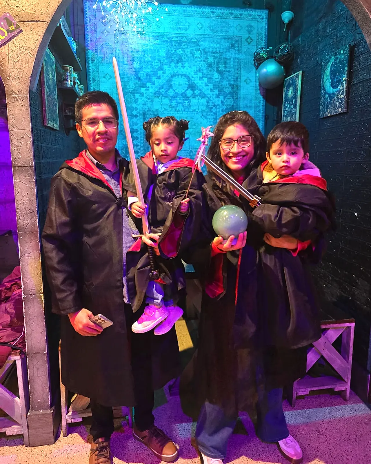 Familia con niños disfrazados con capas y espadas en Arcanum Domus