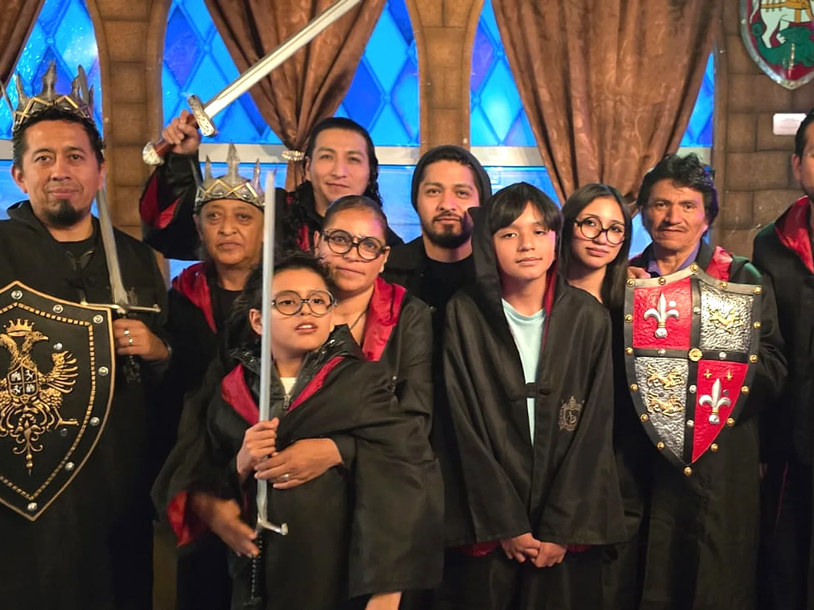 Familia celebrando con capas, espadas y escudos en Arcanum Domus