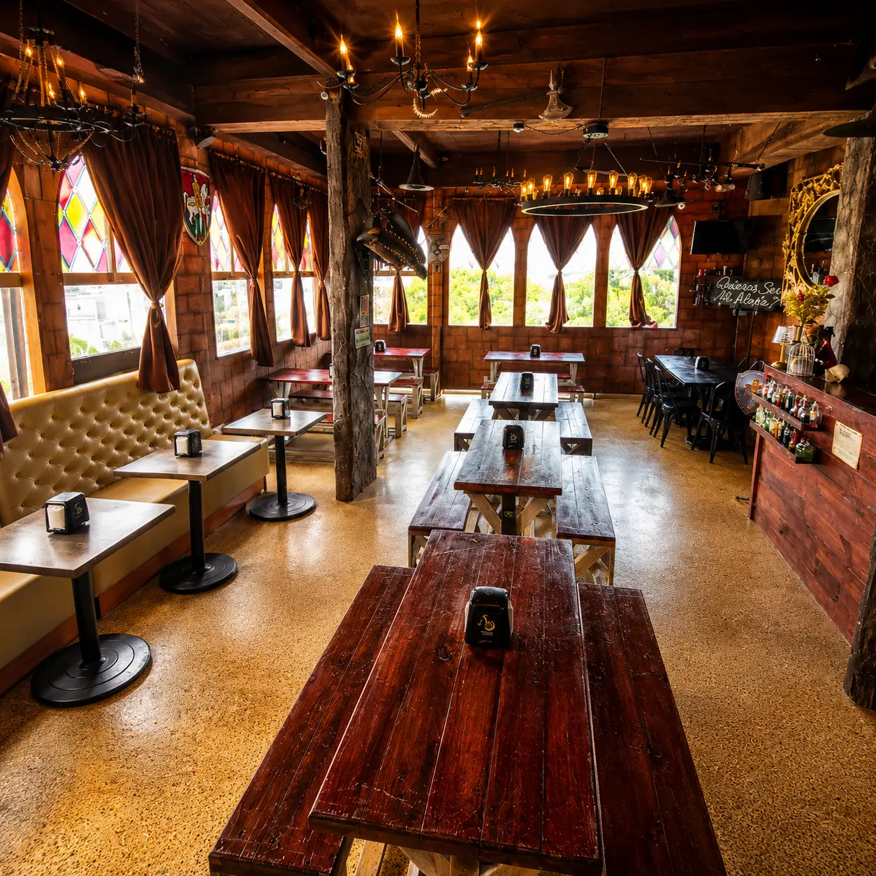 Salón del Banquete Real con luz de día, mesas largas de madera y vitrales