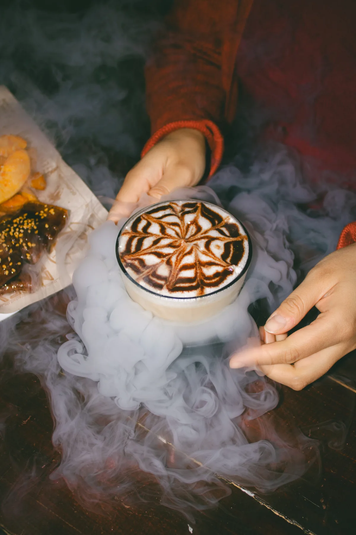 Café con arte latte servido entre bruma fría en Arcanum Domus