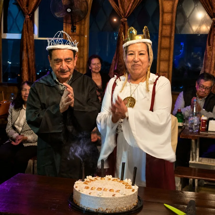 Pareja festejando con coronas y pastel en Arcanum Domus