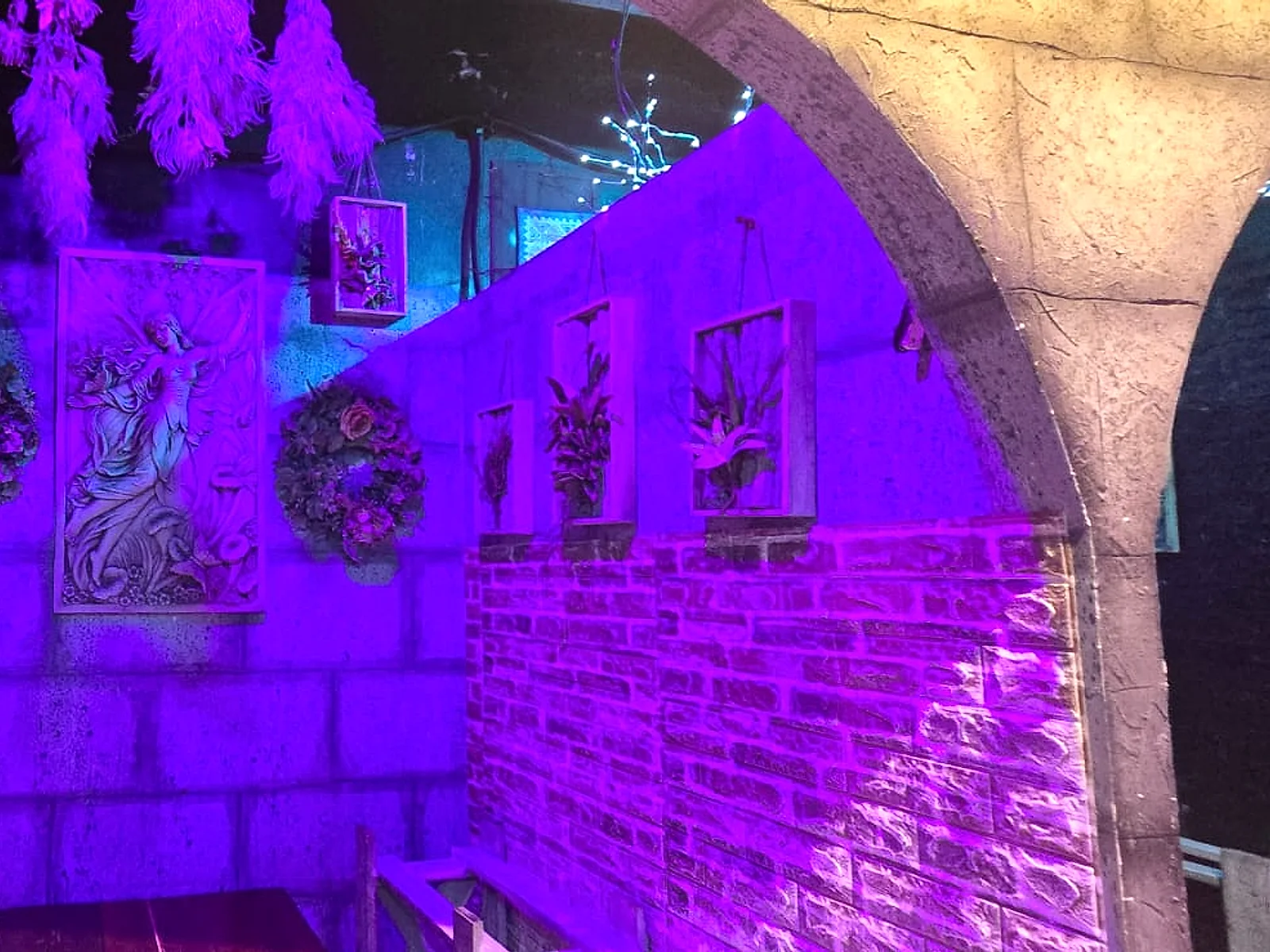 Arco de piedra iluminado en morado en Arcanum Domus